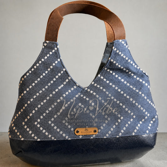 NspiVibe handcrafted hobo handbag in blue fabric with white geometric pattern, navy faux leather base, and brown handles.
