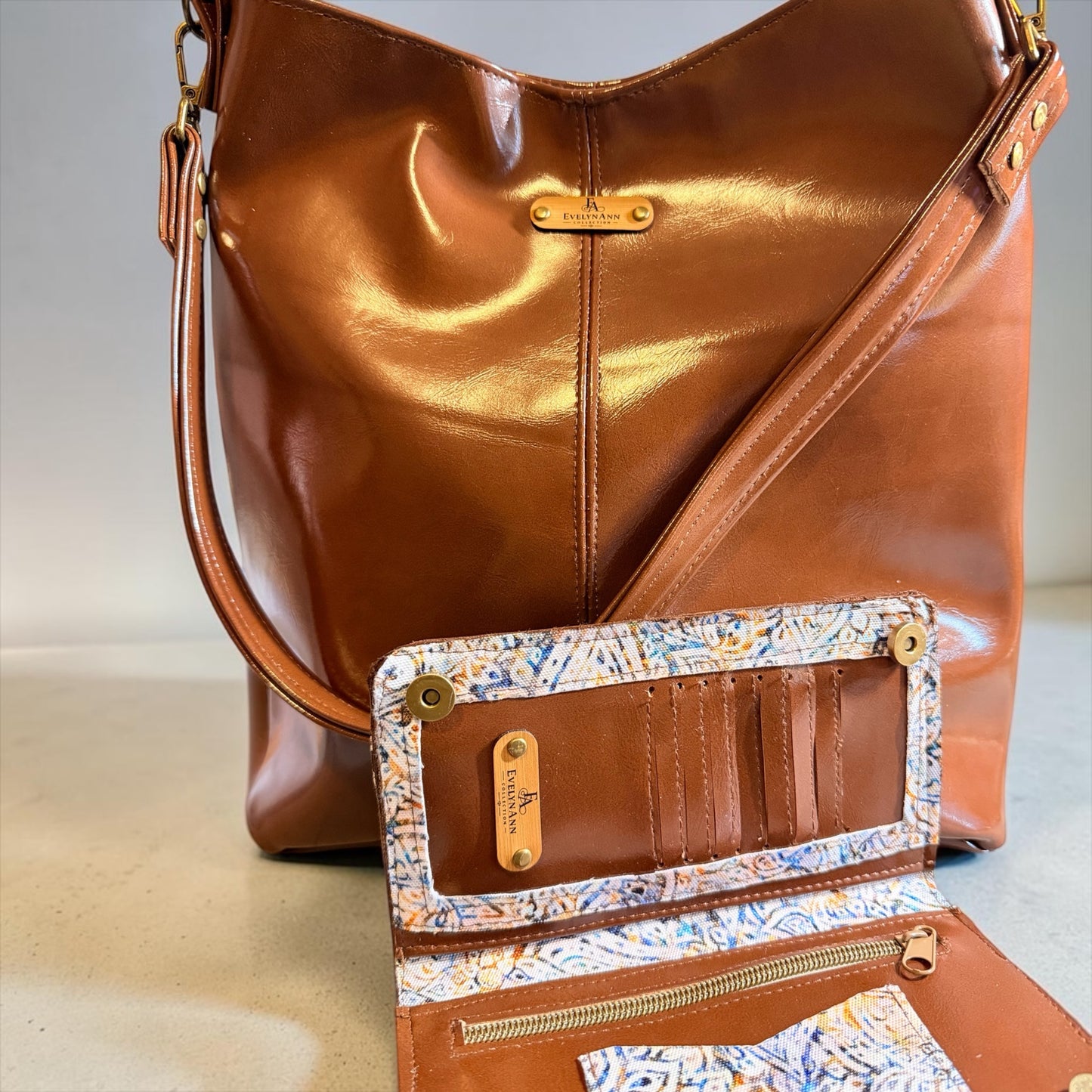 NspiVibe cognac brown hobo bag and matching wallet set with patterned interior lining and gold-tone hardware.